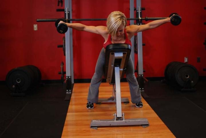 Разводка гантелей в стороны в наклоне с упором